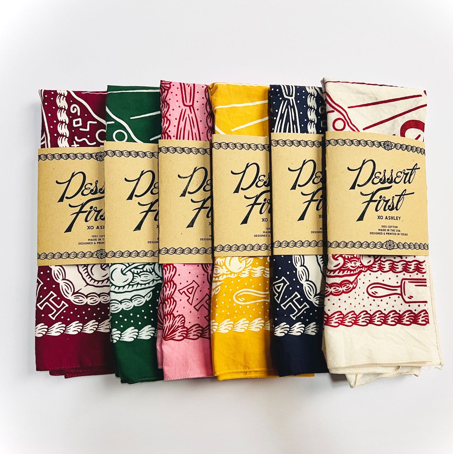 collection of Dessert First bandanas - wine, hunter green, pink, gold, navy and natural